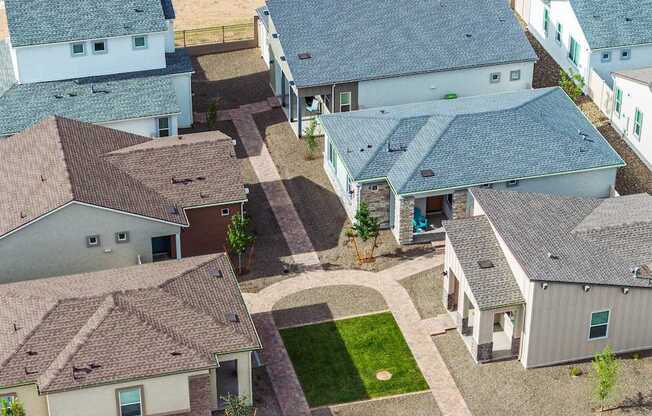 A bird's eye view of a neighborhood with houses and a green lawn.
