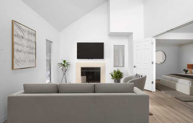 a living room with a gray couch and a fireplace