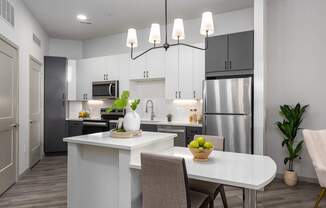 A modern kitchen with a dining table set for two.
