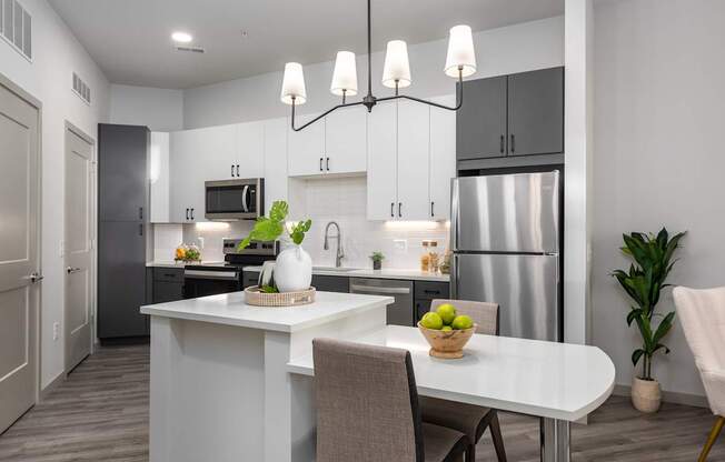 A modern kitchen with a dining table set for two.