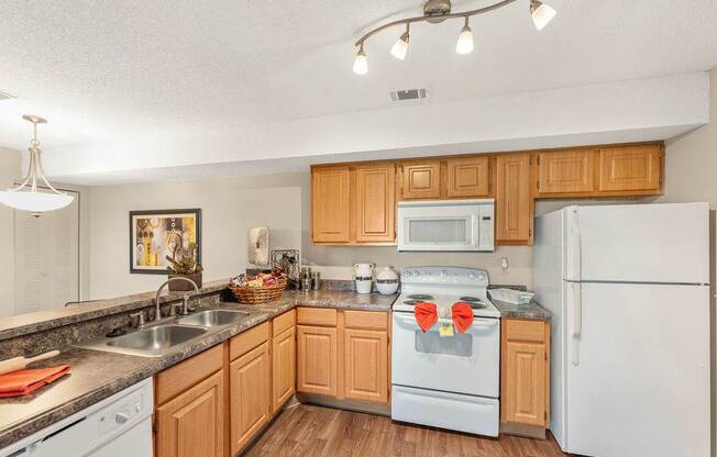 A kitchen with wooden cabinets and white appliances.