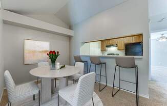 A dining room with a white table and chairs.