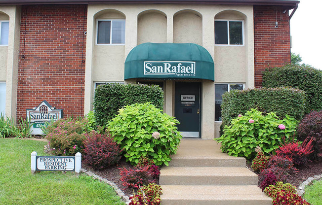 a building with a green awning and flowers in front of it