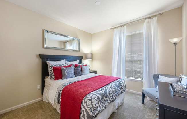 a bedroom with a bed and a desk and a window