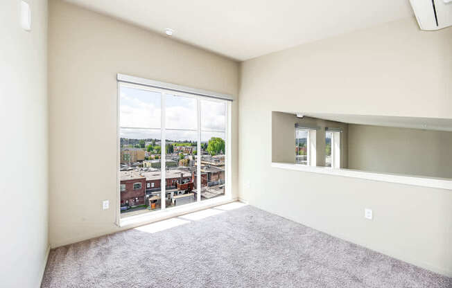 A room with a large window overlooking a cityscape.