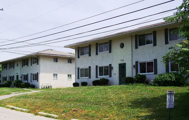 a row of white houses with a grassy yard