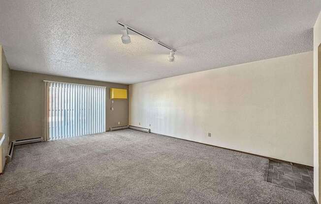 an empty living room with blinds on the window