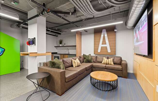A modern office lounge with a brown sofa and a wooden coffee table.