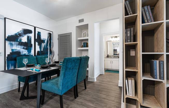 Dining area with built-in shelving, table, and chairs at Cyan Craig Ranch apartments for rent in McKinney, TX