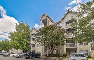 an apartment building with cars parked in front of it at Sanger Place, Lorton, VA