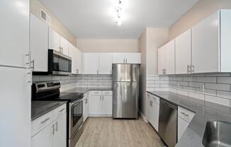 a kitchen with white cabinets and stainless steel appliances