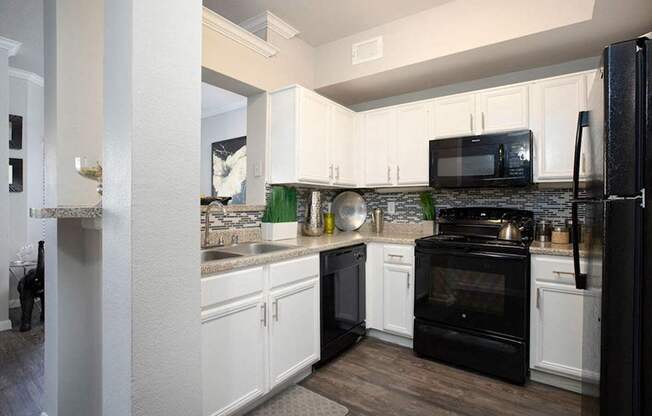 a kitchen with black appliances and white cabinets