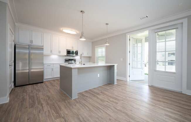 a kitchen with white cabinets and a large island