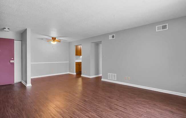 a living room with hardwood floors and grey walls