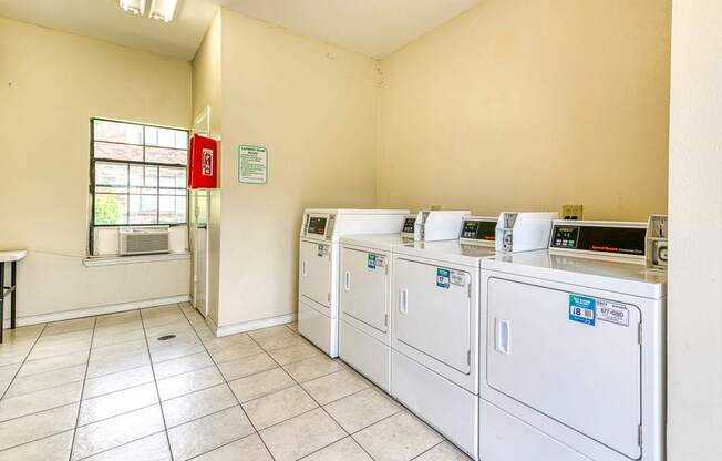 A laundry room with washers and dryers.