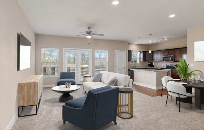 a living room and kitchen with a couch and chairs