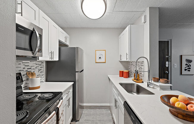 A kitchen with white cabinets and a black stove top.