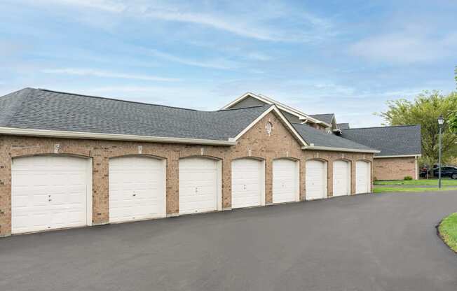 a row of three garage doors on a brick building