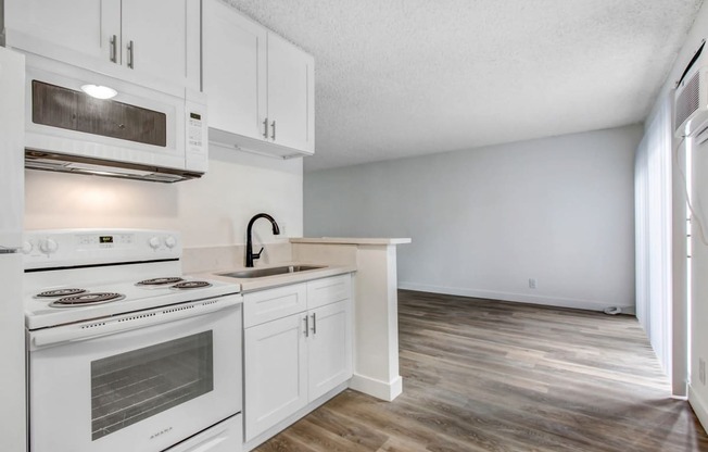 a kitchen with white cabinets and a white stove top oven