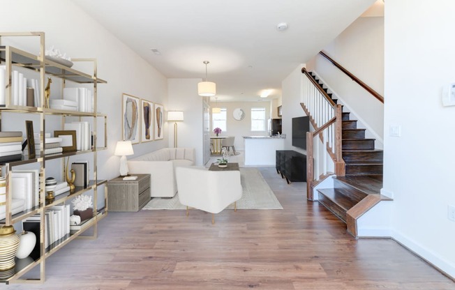 view of large living area with sofa, sitting area, bookshelves and staircase at sheridan station south townhomes in washington dc