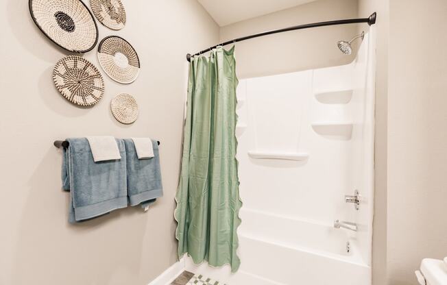 a bathroom with a shower and towels and a sink
