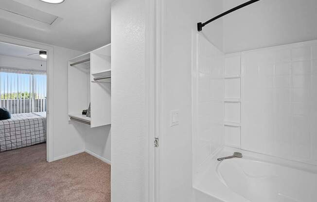 A white bathroom with a tub and a window.