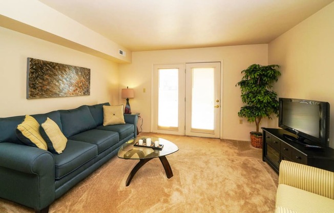Spacious Living Room Leads To Private Patio at Oak Shores Apartments in Oak Creek, WI