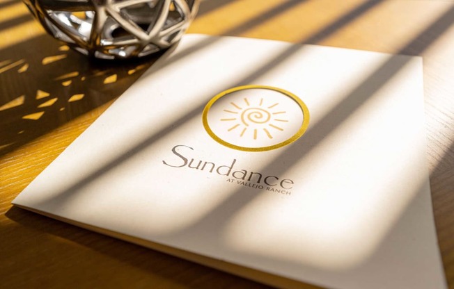 a napkin with a sun dance logo on a table