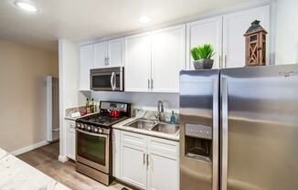 A kitchen with a stove, oven, refrigerator, and microwave.