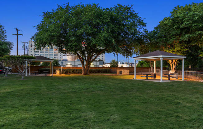 A park with a gazebo and a tree in the center.