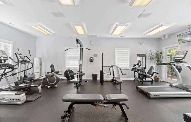 a gym with treadmills and other exercise equipment and windows