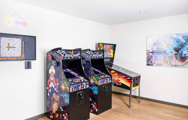 Two arcade style game machines with a table and chairs in between.