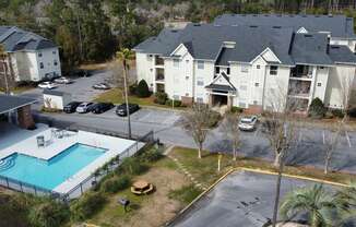 an aerial view of a swimming pool in front of an apartment building