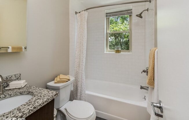 a bathroom with a bathtub and toilet in a 555 waverly unit