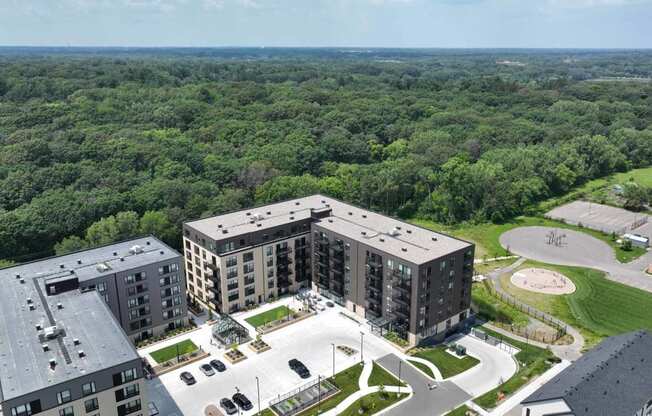 an aerial view of three apartment buildings and a parking lot