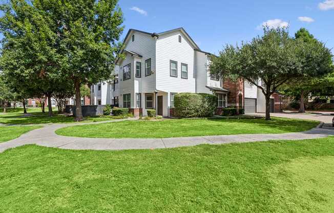 A white building with a green lawn in front.