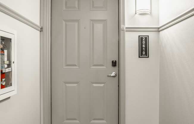 a white door in a hallway with a white wall and a door knob