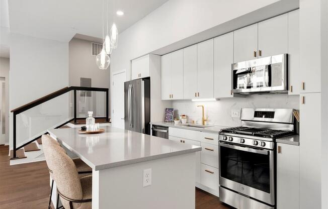 white apartment kitchen with stainless steel appliances and island