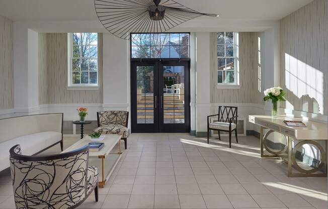 a living room with a white tile floor and a glass door