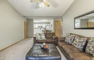 Furnished living room with brown sofa and black ottoman