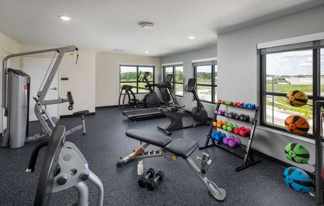 a gym with weights and other exercise equipment and windows