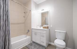A white bathroom with a toilet, sink, and bathtub.