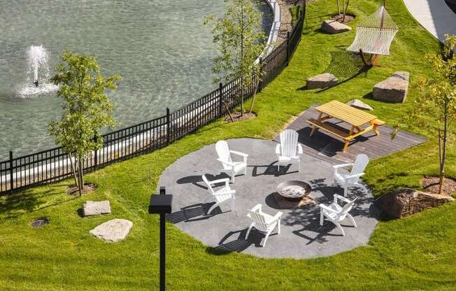 a park with tables and chairs near a body of water