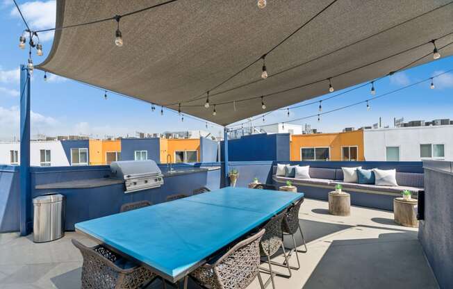 outdoor covered patio with grills and al fresco dining and lounging area at One Santa Fe apartments