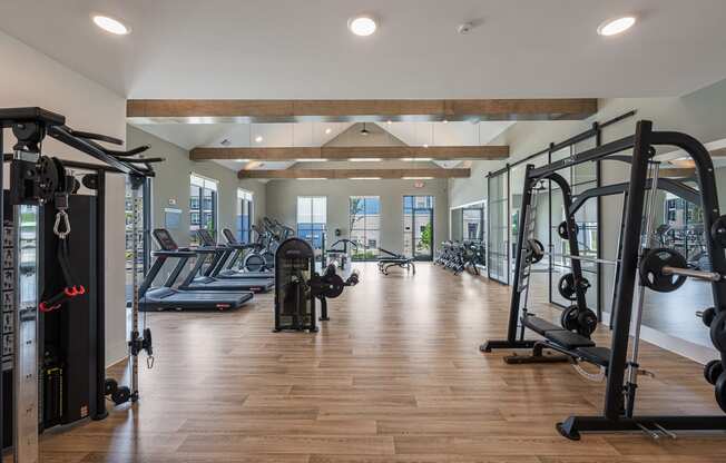 a gym with weights and other exercise equipment on a wood floor