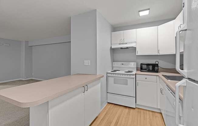 A kitchen with white appliances and cabinets.