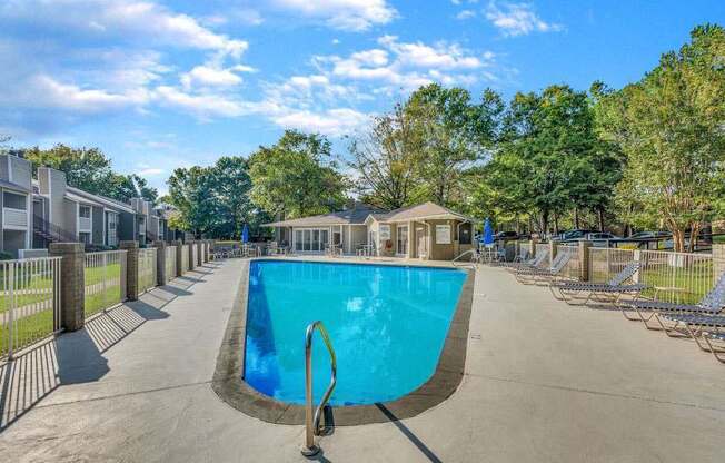 A swimming pool surrounded by a fence and trees.