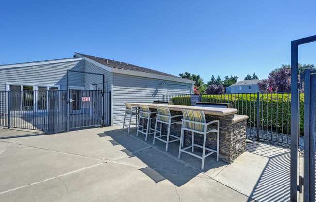 BBQ Picnic Area with Grills and View of Lounge Chairs and Pool at Silverstone Apartments, Davis, California