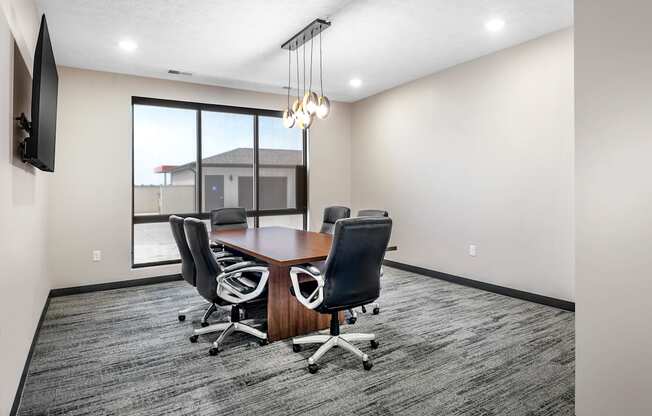 A conference room with a large table and chairs.