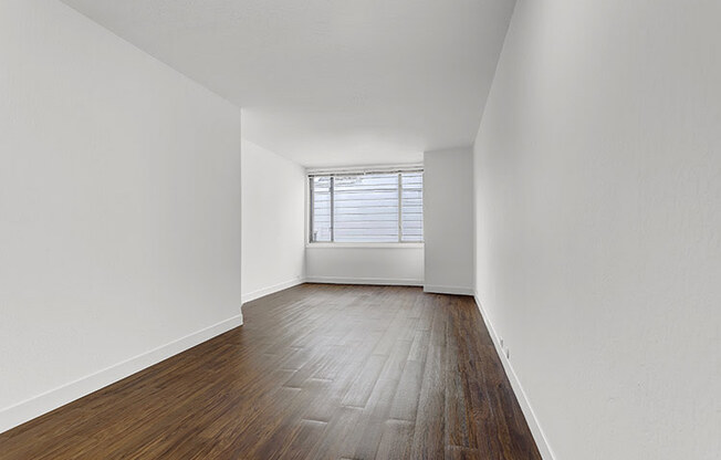 a bedroom with hardwood floors and a window